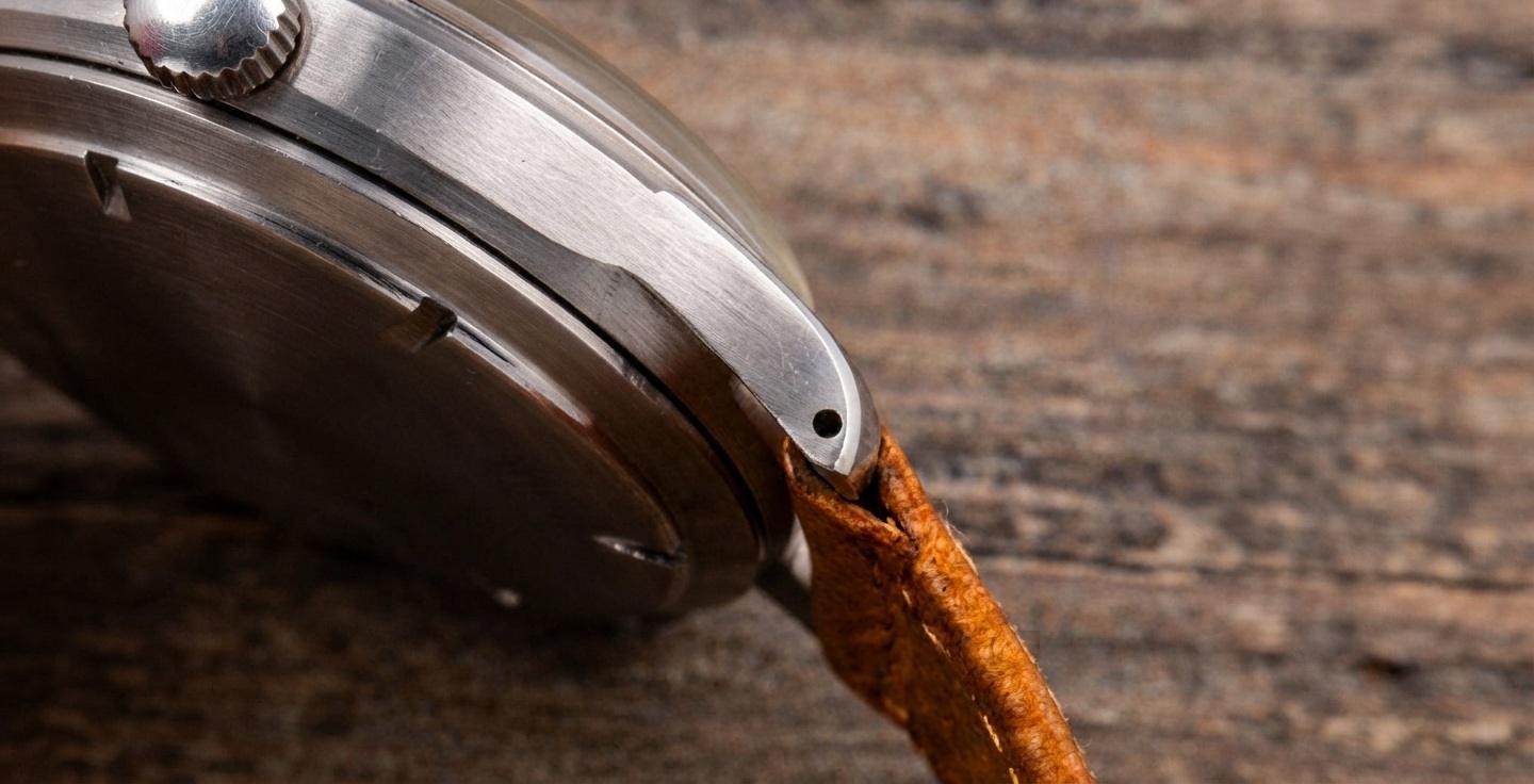 Gros plan d'un doigt appuyant sur le poussoir d'une barrette quick-release pour retirer un bracelet de montre sans outil